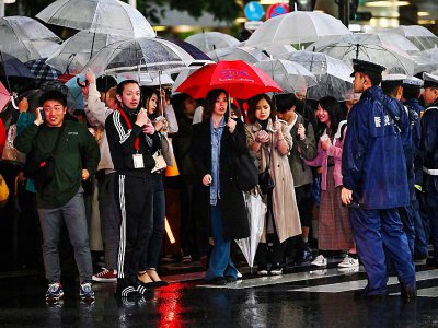La nouvelle ère impériale Reiwa commmence sous la pluie pour des Japonais massés dans le quartier de Shibuya à Tokyo au moment de la cérémonie d'abdication, le 30 avril 2019. - CHARLY TRIBALLEAU [AFP]