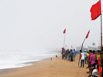 Des Indiens regardent la mer agitée sur une plage fermée au public, le 2 mai 2019 à Puri, dans l'est de l'Inde - Dibyangshu SARKAR [AFP]