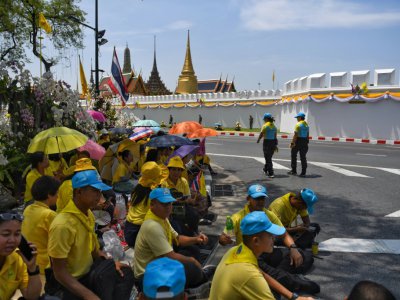 Des Thaïlandais attendent près du Grand palais le passage de la grande parade pour le couronnement du roi Maha Vajiralongkorn dans les rues de Bangkok, le 5 mai 2019 - Lillian SUWANRUMPHA [AFP]