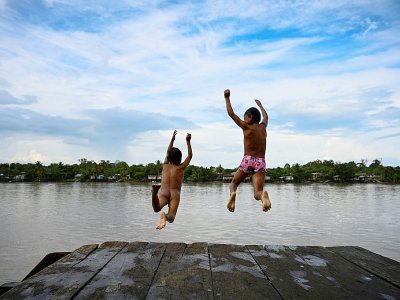Des enfants de l'ethnie Wounaan sautent dans le fleuve San Juan, dans le département du Choco en Colombie, le 24 avril 2019 - Raul ARBOLEDA [AFP]