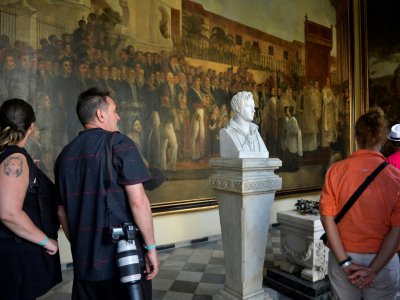 Des touristes admirent une peinture de Jean-Bapstiste Vermay, à La Havane, à Cuba, le 12 avril 2019 - YAMIL LAGE [AFP/Archives]
