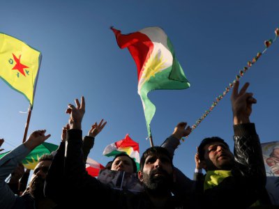 Des kurdes syriens agitent des drapeaux kurdes et l'emblème du YPG, en février 2018 à Erbil, capitale de la région autonome du Kurdistan, en Irak - SAFIN HAMED [AFP/Archives]