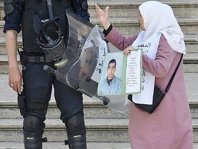 Une manifestanate algérienne interpelle un policier lors du rassemblement du 17 mai 2019 à Alger - RYAD KRAMDI [AFP]