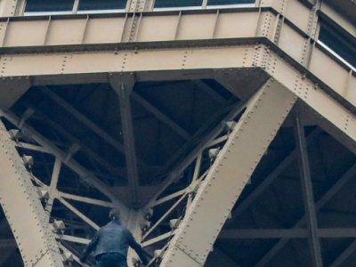 Un homme grimpe la tour Eiffel sous le regard d'un pompier, le 20 mai 2019 à Paris - FRANCOIS GUILLOT [AFP]