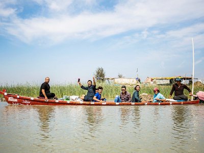Des touristes en barque dans les marais du sud de l'Irak, le 29 mars 2019 à Chibayich - Hussein FALEH [AFP]