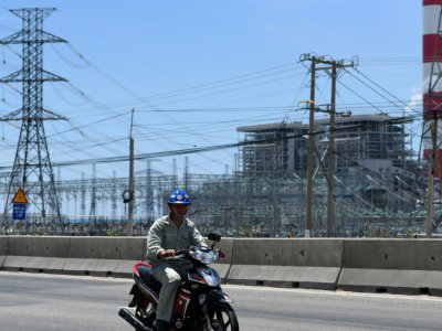 Un motard passe devant la centrale à charbon Vinh Tan dans le sud-ouest du Vietnam, le 23 avril 2019 - Manan VATSYAYANA [AFP]