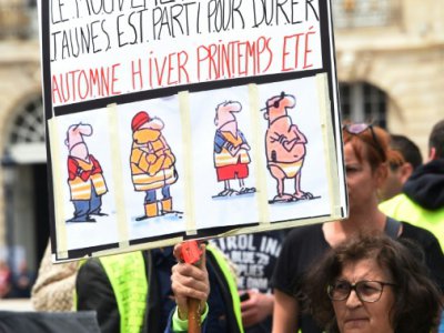 Un "gilet jaune" tient une pancarte pendant une manifestation à Bordeaux, le 25 mai 2919. - MEHDI FEDOUACH [AFP]