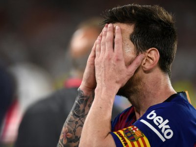 Lionel Messi, le capitaine du FC Barcelone, se couvre le visage à la fin de la finale de la Coupe d'Espagne perdue 2-1 face à Valence, le 25 mai 2019 à Séville - JOSE JORDAN [AFP]
