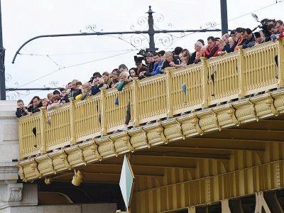 Des passants se pressent au bord d'un pont, à Budapest, le 30 mai 2019 - Attila KISBENEDEK [AFP]