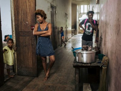 Willy, Jessica et un enfant, dans un couloir de l'hôpital de l'ancienne plantation de cacao abandonnée Agostinho Neto, à Sao Tomé-et-Principe le 12 mai 2019 - Alexis HUGUET [AFP]