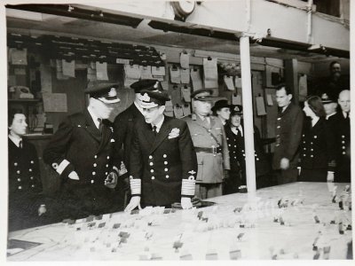 Une reproduction d'une photo en noir et blanc datant de 1944 et montrée à l'AFP par une ex-standardiste le Jour J montrant le roi d'Angleterre Georges VI en déplacement au QG des forces alliées à Portsmouth. - HO [MARIE SCOTT/AFP]