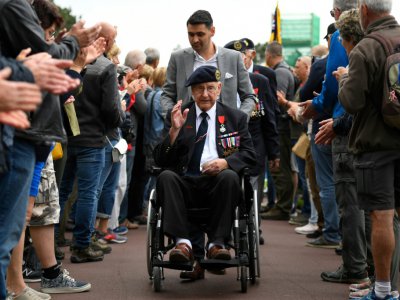 Un vétéran britannique est applaudi par des habitants après une cérémonie au cimetière de Colleville-sur-Mer, près d'Omaha Beach, le 4 juin 2019 - Damien MEYER [AFP]