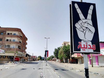 Un panneau sur lequel est écrit en arabe "Civil et Pacifique" dans une rue déserte de Khartoum au Soudan, le 6 juin 2019 - - [AFP]