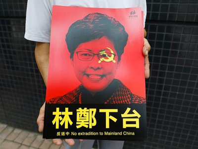 La cheffe de l'exécutif hongkongais, Carrie Lam, représentée sur une affiche tenue par un participant à la manifestation contre un projet de loi d'extradition, le 9 juin 2019 - DALE DE LA REY [AFP]