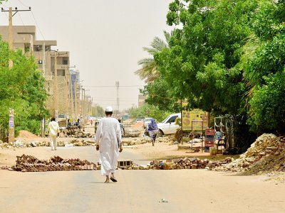 Un habitant de Bahri, en banlieue nord de Khartoum, marche au milieu des barricades erigées par des manifestants, le 9 juin 2019 - - [AFP]