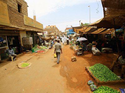 Des Soudanais marchent à travers le marché central de Khartoum, le 10 juin 2019 - - [AFP]