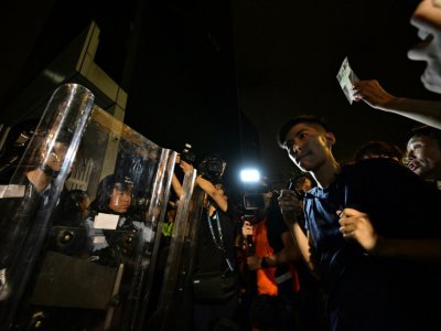 Le militant Lester Shum (d) parle aux forces de l'ordre lors d'une manifestation, le 12 juin 2019 à Hong Kong - Anthony WALLACE [AFP]