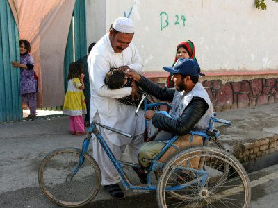 Un membre de la campagne de vaccination contre la poliomyélite administre une dose de vaccin à un enfant, le 20 mars 2019 dans la province de Kandahar, en Afghanistan - JAVED TANVEER [AFP]