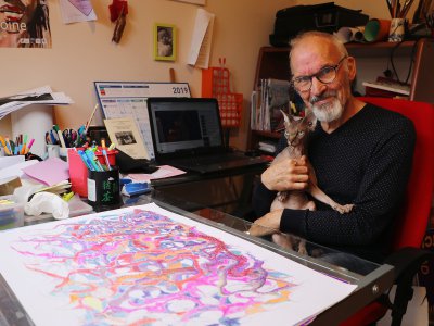 Patrick Pels et sa mascotte, devant l'un des dessins au stylo à bille, en cours de réalisation. - Amaury Tremblay