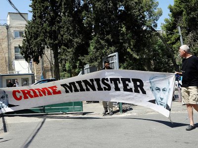 Un homme proteste contre le Premier ministre israélien Benjamin Netanyahu le 16 juin 2019 devant le tribunal de Jerusalem où la femme de M. Netanyahu, Sara, a été reconnue coupable de mauvais usage de fonds publics - GALI TIBBON [AFP]