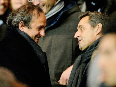 Michel Platini, alors président de l'UEFA, en discussion avec Nicolas Sarkozy lors du huitième de finale de Ligue des champions entre le Paris Saint-Germain (PSG) et Chelsea au Parc des Princes, le 17 février 2015 - MIGUEL MEDINA [AFP/Archives]