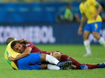 Le Vénézuélien Arquimedes Figuera (au-dessus) enlace le Brésilien Fernandinho au sol en Copa América, le 18 juin 2019 à Salvador (Brésil) - Raul ARBOLEDA [AFP]