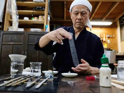 Le conservateur Takao Makino utilise du washi pour restaurer des oeuvres d'art, le 4 juin 2019 à Saitama, au Japon - Kazuhiro NOGI [AFP]