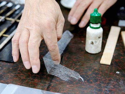 Le conservateur Takao Makino utilise du washi pour restaurer des oeuvres d'art, le 4 juin 2019 à Saitama, au Japon - Kazuhiro NOGI [AFP]