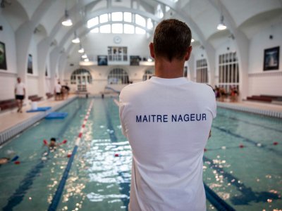 Un maître-nageur surveille des enfants à la piscine de la Butte aux Cailles à Paris, le 20 juin 2019 - Thomas SAMSON [AFP]