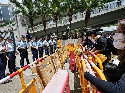 Des manifestants mettent en place des barrières devant le siège de la police, le 21 juin 2019 à Hong Kong - Anthony WALLACE [AFP]
