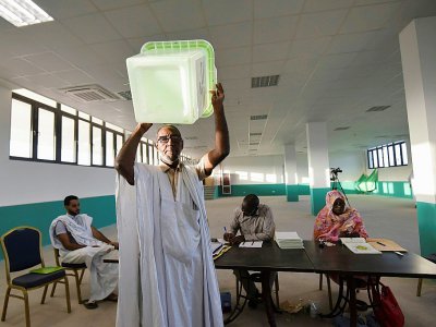 Une urne vide brandie avant l'ouverture d'un bureau de vote pour la présidentielle en Mauritanie, le 22 juin 2019 à Nouakchott. - Sia KAMBOU [AFP]