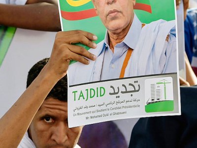Un partisan du candidat du pouvoir à la présidentielle en Mauritanie, l'ex général 
Mohamed Ould Ghazouani, brandit son portrait lors d'un meeting électoral le 20 juin 2019 à Nouakchott. - SIA KAMBOU [AFP]