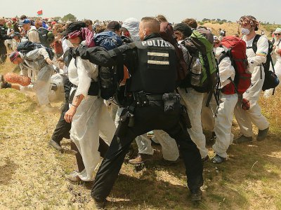 Des policiers tentent d'empêcher des militants écologistes de pénétrer sur le site de la mine de charbon de Garzweiler, dans l'ouest de l'Allemagne, le 22 juin 2019 - David Young [DPA/AFP]