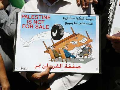 "La Palestine n'est pas à vendre", indique une affiche brandie par un manifestant à Ramallah, en Cisjordanie, le 24 juin 2019 - ABBAS MOMANI [AFP]