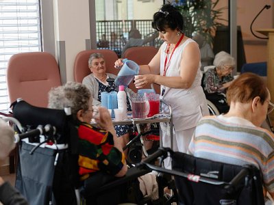 Une aide-soignante sert des rafraîchissements aux pensionnaires d'une maison de retraite à Souffelweyersheim, dans l'Est de la France, le 24 juin 2019 - PATRICK HERTZOG [AFP]