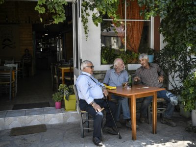 Des habitants de l'île de Samos attablés dans un café de Mytilinoi, le 19 juin 2019 - LOUISA GOULIAMAKI [AFP]