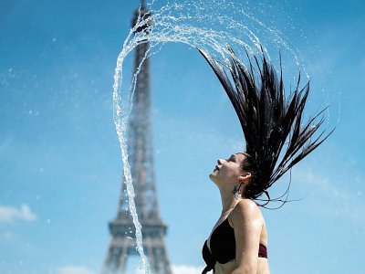 Une femme se rafraîchit dans une fontaine de l'esplanade du Trocadéro à Paris, le 25 juin 2019 - Kenzo TRIBOUILLARD [AFP]