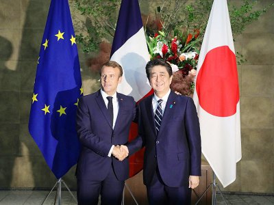 Poignée de mains du président français  Emmanuel Macron (L) échangée avec le Premier ministre japonais Shinzo Abe lors d'une rencontre à Tokyo le 26 juin 2019 - LUDOVIC MARIN [POOL/AFP]