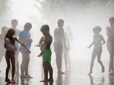 Des enfants se rafraîchissent dans des fontaines à Madrid, le 26 juin 2019 - Pierre-Philippe MARCOU [AFP]