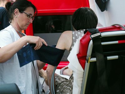 Une secouriste prend la tension d'une femme souffrant de la chaleur, à Tours, le 27 juin 2019 - GUILLAUME SOUVANT [AFP]
