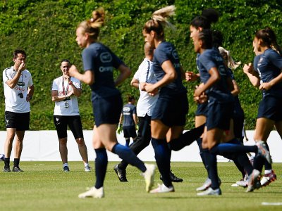 La sélectionneuse des Bleues Corinne Diacre (2g) et l'entraîneur-ajoint Philippe Joly (g) lors d'une séance d'entraînement, le 27 juin 2019 à Clairefontaine - FRANCK FIFE [AFP]