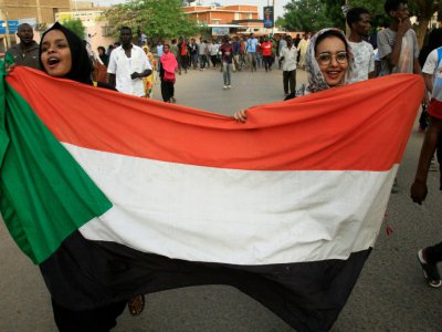 Des femmes soudanaises manifestent contre le Conseil militaire de transistion brandissant le drapeau national le 30 juin 2019 dans le centre de Khartoum - Ebrahim Hamid [AFP]
