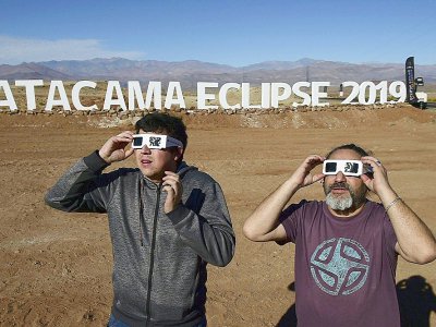Des touristes essaient des lunettes spéciales pour l'éclipse totale de soleil, le 1er juillet 2019 au campement astronomqiue de Vallenar, dans le désert d'Atacama, au Chili - MARTIN BERNETTI [AFP]