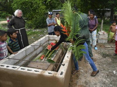 Le Frère Nelson Sandoval de la mission d'El Tucuco entourés par des Yukpas lors d'un enterrement, le 11 juin 2019 au Venezuela - YURI CORTEZ [AFP]