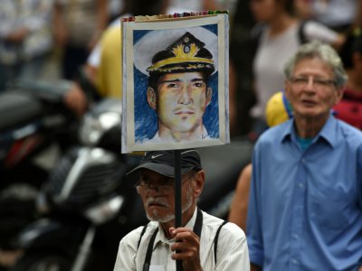 Un homme tient un portrait de l'officier vénézuélien Rafael Acosta - mort en détention - lors d'une manifestation contre le gouvernement à Caracas, le 5 juillet 2019 - YURI CORTEZ [AFP]