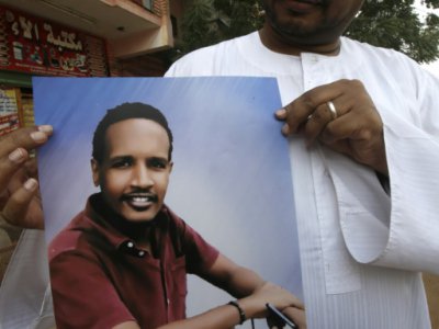 Le frère d'Ali, tué le 3 juin 2019 pendant la dispersion  d'un sit-in à Khartoum, montre son portrait, le 7 juillet 2019 au Soudan - ASHRAF SHAZLY [AFP]