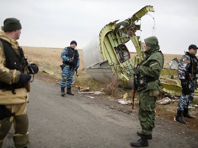 Des soldats pro-Russes et des enquêteurs sur les lieux du crash du vol MH17, près de Grabove, le 11 novembre 2014, dans l'est de l'Ukraine - MENAHEM KAHANA [AFP/Archives]