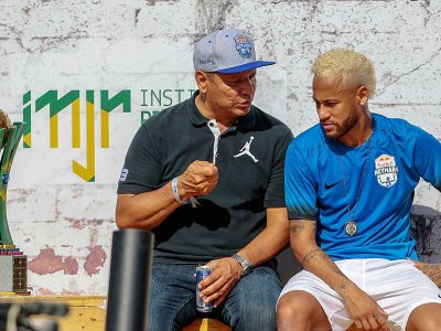 Le footballeur Neymar(d) écoute son père Neymar Senior le 13 juillet lors d'un tournoi au bénéfice de sa fondation à Praia Grande, au Brésil - Miguel SCHINCARIOL [AFP/Archives]