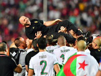 Le sélectionneur de l'Algérie Djamel Belmadi porté par son équipe lors de la victoire en finale de la CAN face au Sénégal au Caire le 19 juillet 2019 - Giuseppe CACACE [AFP]