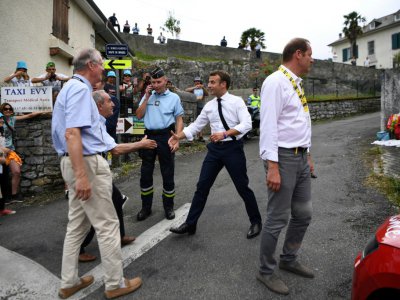 Emmanuel Macron (g)salue un habitant de Tourmalet lors de la 14e étape du Tour de France entre Tarbes et le col du Tourmalet, le 20 juillet 2019 - Anne-Christine POUJOULAT [POOL/AFP]